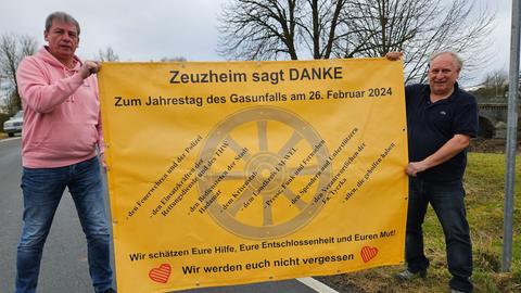 zwei Männer halten Schild hoch mit der Aufschrift "Zeuzheim sagt dankeschön"