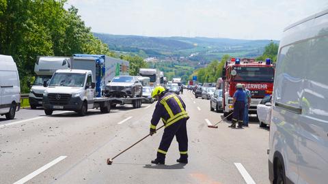 Nach einem Unfall mit insgesamt drei Fahrzeugen wird die A7 von Mitgliedern der Feuerwehr gereinigt. 