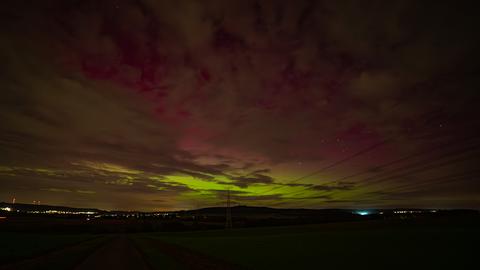 Grünliches Licht am Himmel mit Strommast und Stromleitung