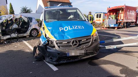 Zwei kaputte Autos auf Straße, eins davon ein Polizeiauto