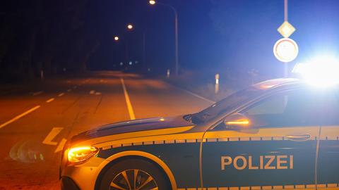 Ein Polizeiauto steht quer auf der Straße und sperrt diese damit.