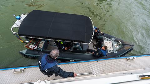 Polizei trainiert auf dem Main für EM-Einsatz - Polizist wechselt von größerem Boot auf kleineres Boot