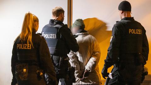 Polizeikräfte kontrollieren einen Mann im Frankfurter Bahnhofsviertel.