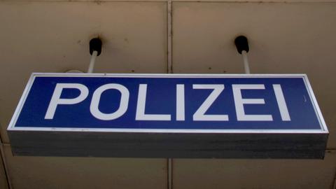 Ein Schild mit der Aufschrift "POLIZEI" hängt von der Decke eines Gebäudes.