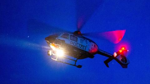 Hubschrauber mit Aufschrift "Polizei" bei Nacht aus der Froschperspektive fotografiert.