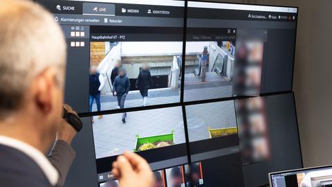 Roman Poseck (CDU), Innenminister von Hessen, nimmt auf einer Polizeiwache ein Videosystem in Augenschein, welches KI-gestützt im Bahnhofsviertel zum Einsatz kommt. Es zeigt den Rolltreppenausgang der U-Bahnstation.