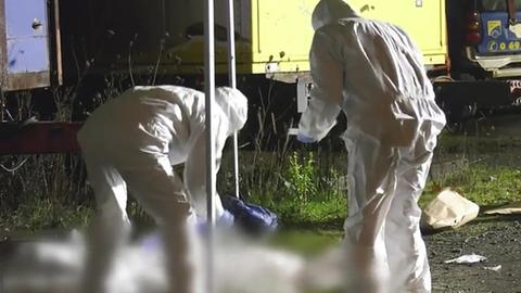 Kriminaltechnische Ermittler der Polizei in weißen Anzügen untersuchen den Tatort in Frankfurt-Praunheim, an dem ein Mann erschossen wurde
