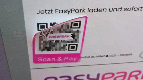 Auf einem Parkautomat klebt ein gefälschter QR-Code