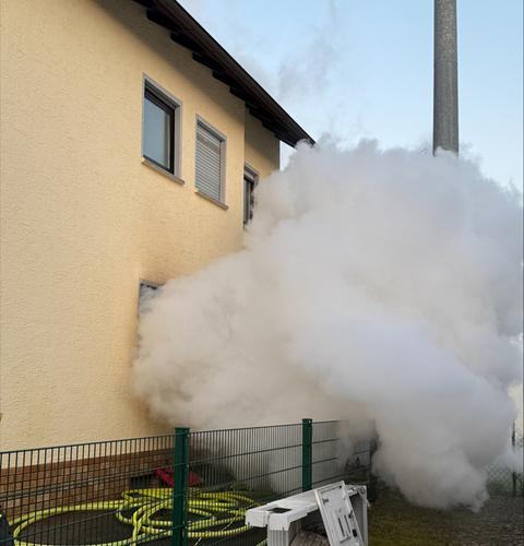 Weiß-grauer Rauch drängt aus Fenster