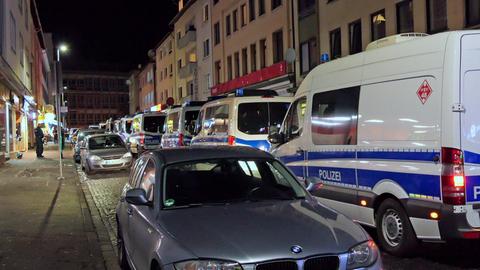 Mehrere Mannschaftswagen der Polizei stehen in einer beleuchteten Straße nahe der Kassler Innenstadt.