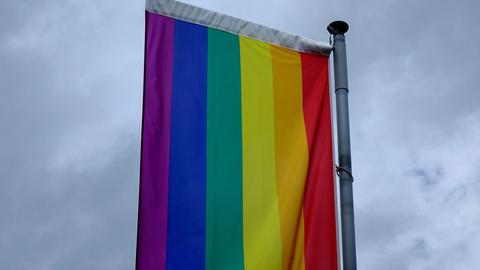 Regenbogenflagge vor dunklen Wolken