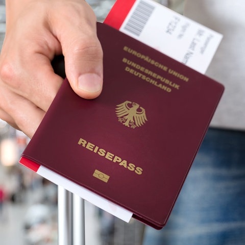 Eine Hand hält einen deutschen Reisepass