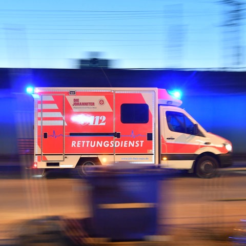  Ein Rettungswagen ist mit eingeschaltetem Blauchlicht im Einsatz.