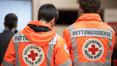 Zwei Rettungssanitäter in einer Rettungswache des Deutschen Roten Kreuzes (DRK).