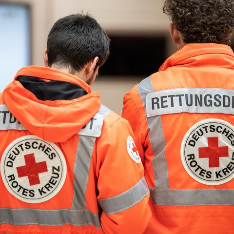 Zwei Rettungssanitäter in einer Rettungswache des Deutschen Roten Kreuzes (DRK).