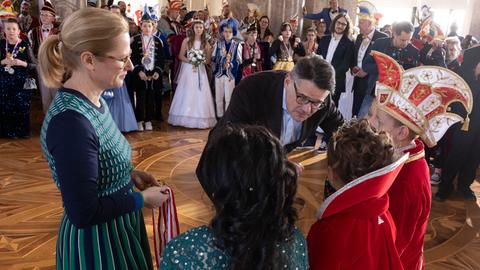 Boris Rhein beim närrischen Empfang der Tollitäten: Er beugt sich zu als Prnizen und Prinzessinnen herunter, im Hintergrund der Schlossaal.