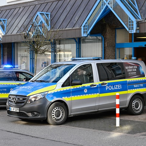 Zwei Polizeiautos stehen vor einer Bankfiliale