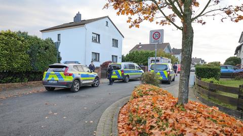 Mehrere Polizeiwagen und ein Krankenwagen stehen vor einem Wohnhaus.