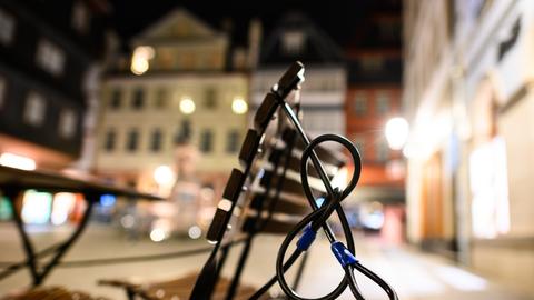 Symbolfoto: Stühle und Tische sind in der Frankfurter Altstadt am Abend durch Stahlseile gesichert. 