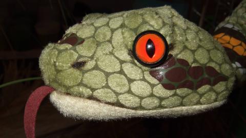 Eine Plüschtier-Schlange mit orangen Augen. 