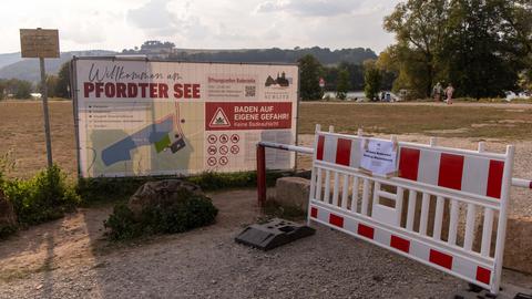 Absperrung vor Wiese und See mit Aufschrift "Pfordter See" und Zettel "Absolutes Badeverbot! Gefahr im Wasserbereich!"