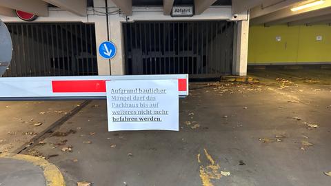 Schranke zum Parkhaus mit Schild, das auf bauliche Mängel hinweist