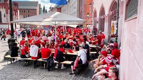 Schweizer Fans sitzen in einem Lokal draußen auf dem Frankfurter Römerberg.