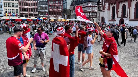 Junge Schweizer Fans schwenken Fahnen auf dem Frankfurter Römerberg.