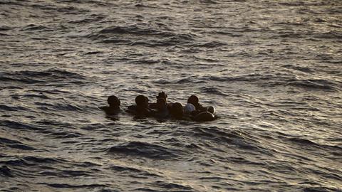 Mehrere Menschen treiben im Mittelmeer im Wasser.