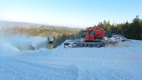 Eine Skipiste mit Schneekanone.