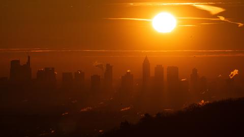 Die Sonne geht über der Bankenskyline von Frankfurt auf.