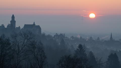 Die Sonne geht bei dichtem Nebel über Kronberg im Taunus auf.