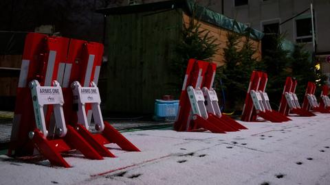 Mobile Fahrzeugsperren sind auf einem Weihnachtsmarkt hinter den Buden zu sehen.