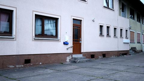 Foto eines Wohnhauses von außen mit polizeilichem Siegel an der Haustür.