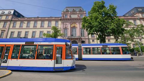 Straßenbahnen fahren vor dem Darmstädter Schloss vorbei