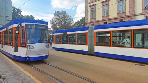 Straßenbahnen fahren vor dem Darmstädter Schloss über den neuen Straßenbelag "Busphalt".