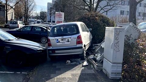 Auto auf einem Gehweg neben dem zerstörten Stromverteilerkasten