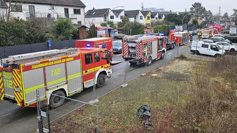 Zahlreiche Feuerwehrautos sind auf einer Straße in einem Wohngebiet abgestellt.