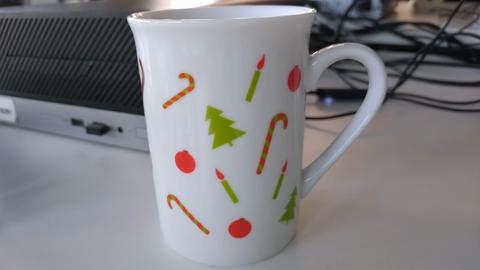 Weiße Tasse mit bunten Kerzen, Weihnachtsbäumen, Zuckerstangen