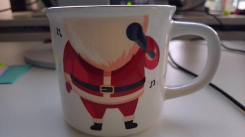 Tasse mit Goldrand und Weihnachtsmannmotiv, mit Mikrofon aber ohne Kopf abgebildet