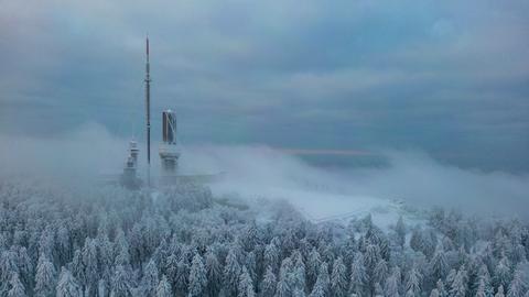 Das Plateau auf dem Großen Feldberg oberhalb von schneebedeckten Bäumen im Taunus