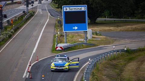 Ein Polizeiauto sperrt eine Autobahnausfahrt auf der A5 zum Terminal 3 des Flughafens Frankfurt ab.