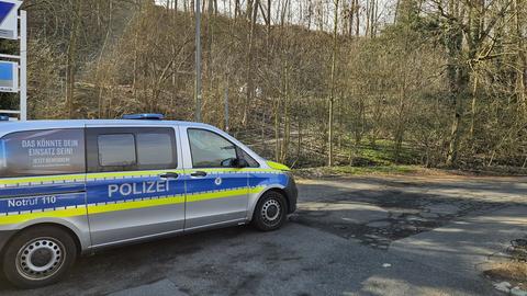 Ein Einsatzfahrzeug der Polizei steht auf einer Straße. Im Hintergrund sind Bäume und Sträucher zu sehen.