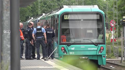 Ein Gruppe Polizisten am Unfallort. Die U-Bahn der Linie U7 steht an der Station "Hausener Weg"