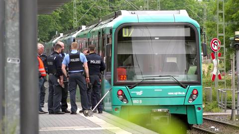 Ein Gruppe Polizisten am Unfallort. Die U-Bahn der Linie U7 steht an der Station "Hausener Weg"