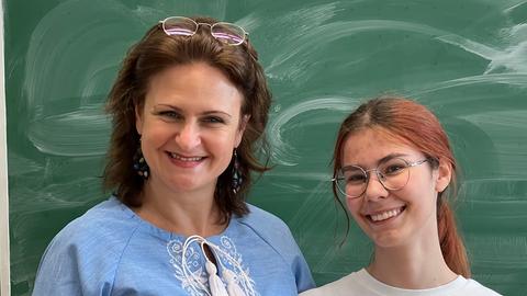 Galyna Nesterenko und Marta Bodnia vom Ukrainer-Verein aus Taunusstein - beide lächeln in die Kamera - rechts: junge Frau mit Brille und rötlichen Haaren zum Zopf gebunden, links: dunkelhaarige Frau mit blauer Bluse