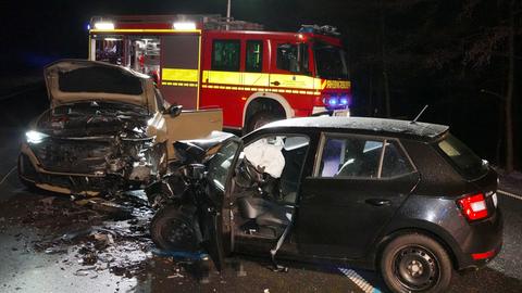 Zwei Autos stehen nach einem Unfall auf der Straße, im Hintergrund ein Feuerwehrwagen