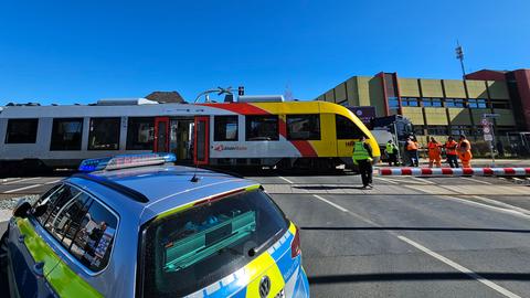 Polzeiauto vor Bahnübergang mit stehendem Zug