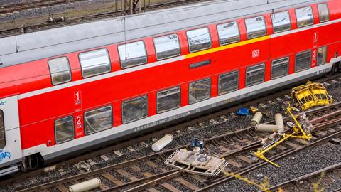 Ein Regionalzug steht in einem Bahnhof, daneben liegen Gasflaschen auf Gleisen.