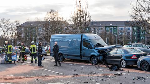 Polizisten und Feuerwehrleute an einem Unfallort in Wiesbaden-Biebrich. Ein beschädigter Lieferwagen und ein beschädigtes Auto stehen auf der Straße.